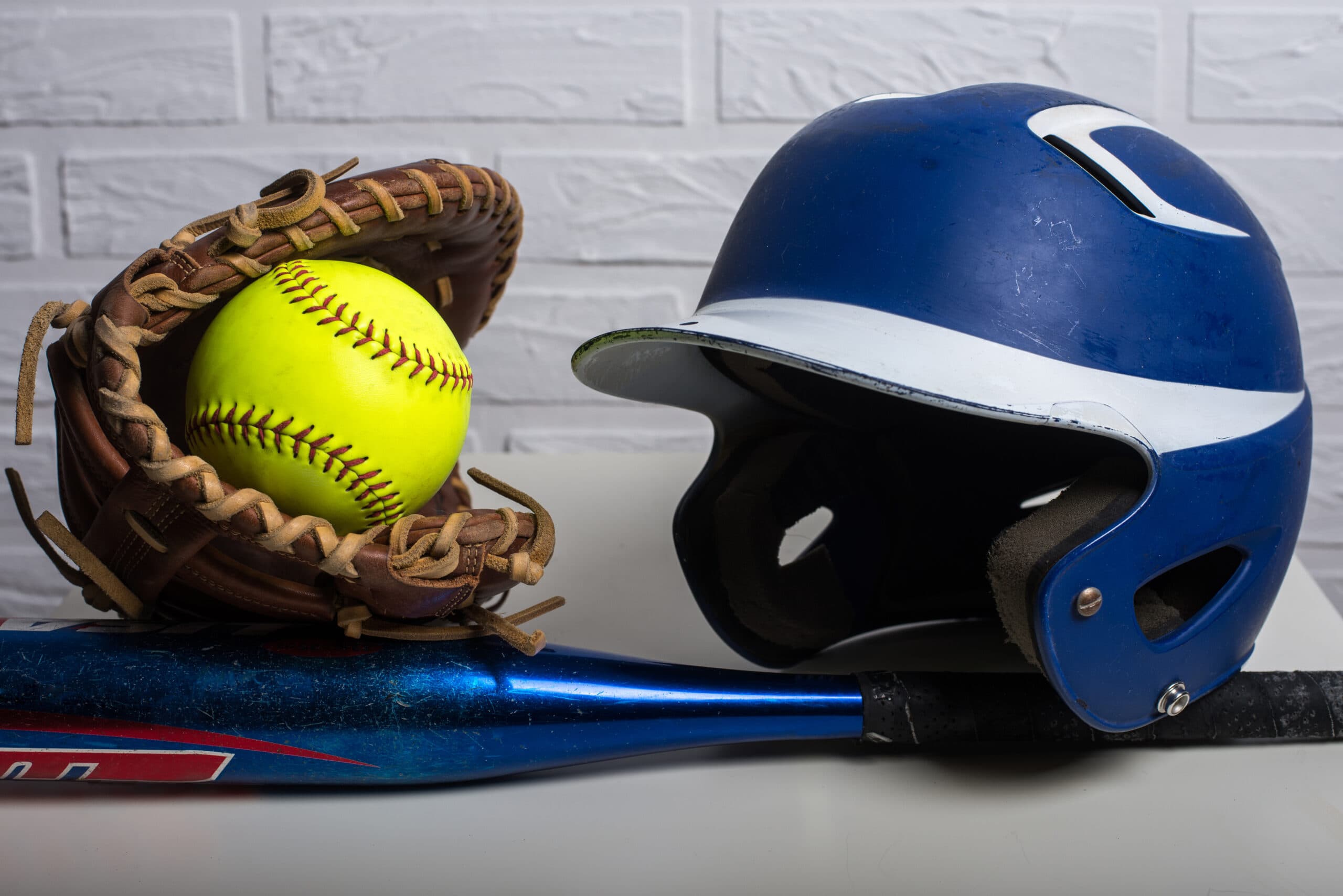 Yellow Softball, Helmet, Bat, and Glove isolated on white background